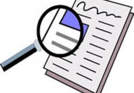 Magnifying glass inspecting a newspaper